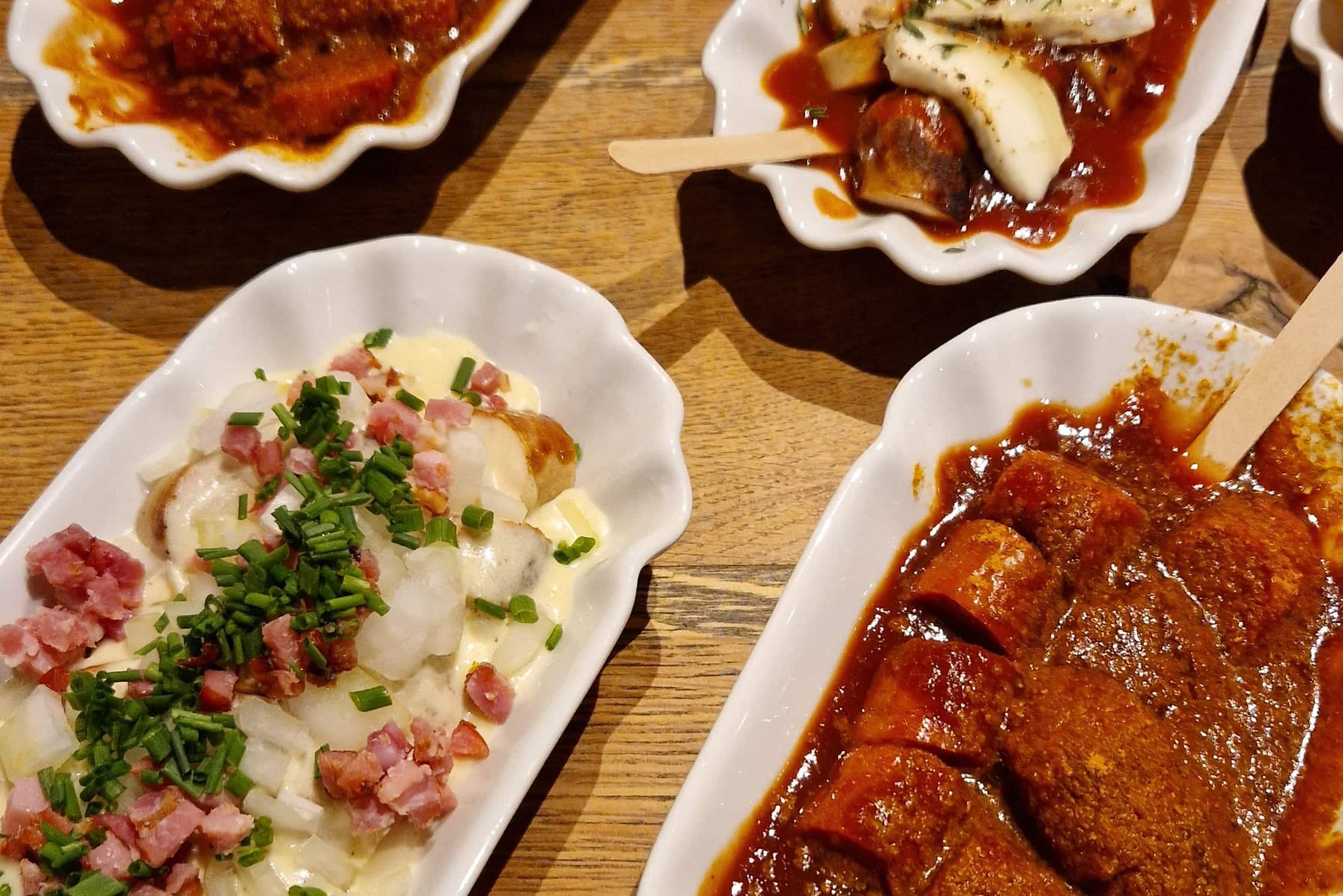 Verschiedene Currywürste stehen auf einem Tisch. Das Kalinski in Saarbrücken gehört für Davide zu den besten Restaurants Deutschlands.