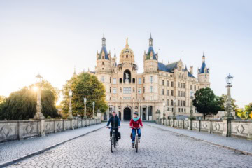 Schweriner Schloss mit zwei Fahrradfahrern