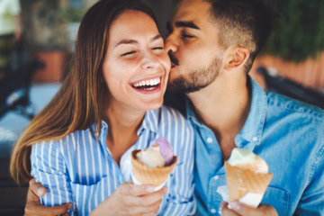 glücklicher Mann und Frau mit Eis in der Hand