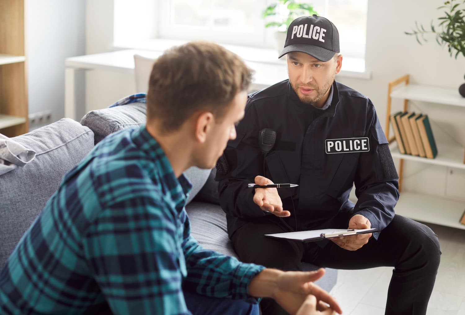Mann spricht mit Polizist nach Einbruch im Airbnb