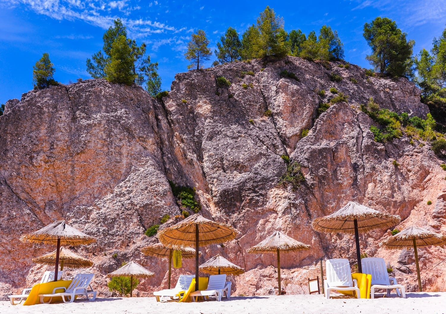 Liegen am Praia de Albarquel bei Setubal vor roten Felsen
