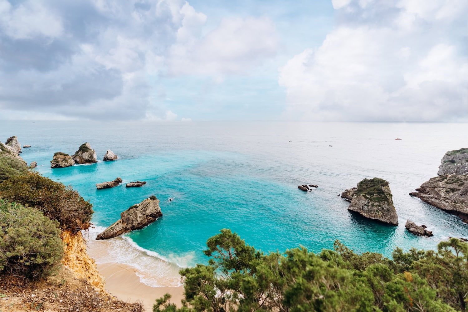 Blick auf den Praia do Ribeiro do Cavalo mit seinem türkisen Wasser gerahmt von Felsen