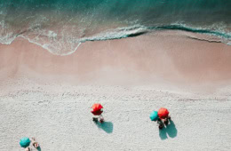 Strand in sardinien von oben mit Sonnenbadenden unter einem Sonnenschirm