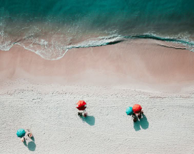 Strand in sardinien von oben mit Sonnenbadenden unter einem Sonnenschirm
