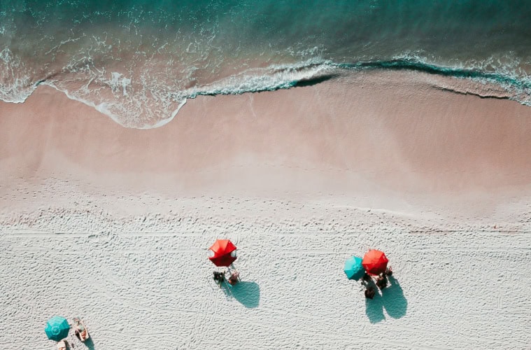 Strand in sardinien von oben mit Sonnenbadenden unter einem Sonnenschirm