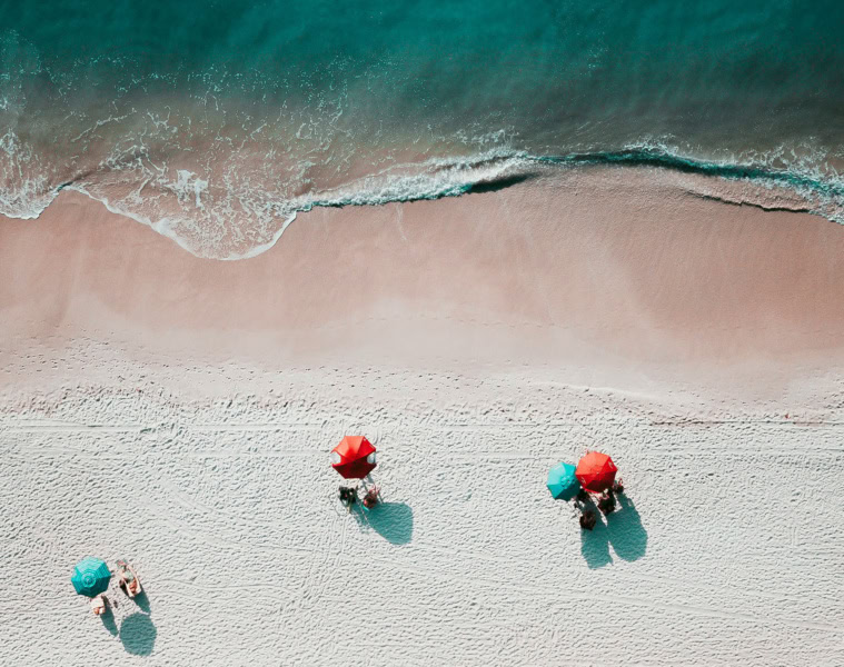 Strand in sardinien von oben mit Sonnenbadenden unter einem Sonnenschirm