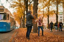 Herbst in Göteborg in Schweden: Ein Mädchen wirft bunte Blätter auf einen Mann.