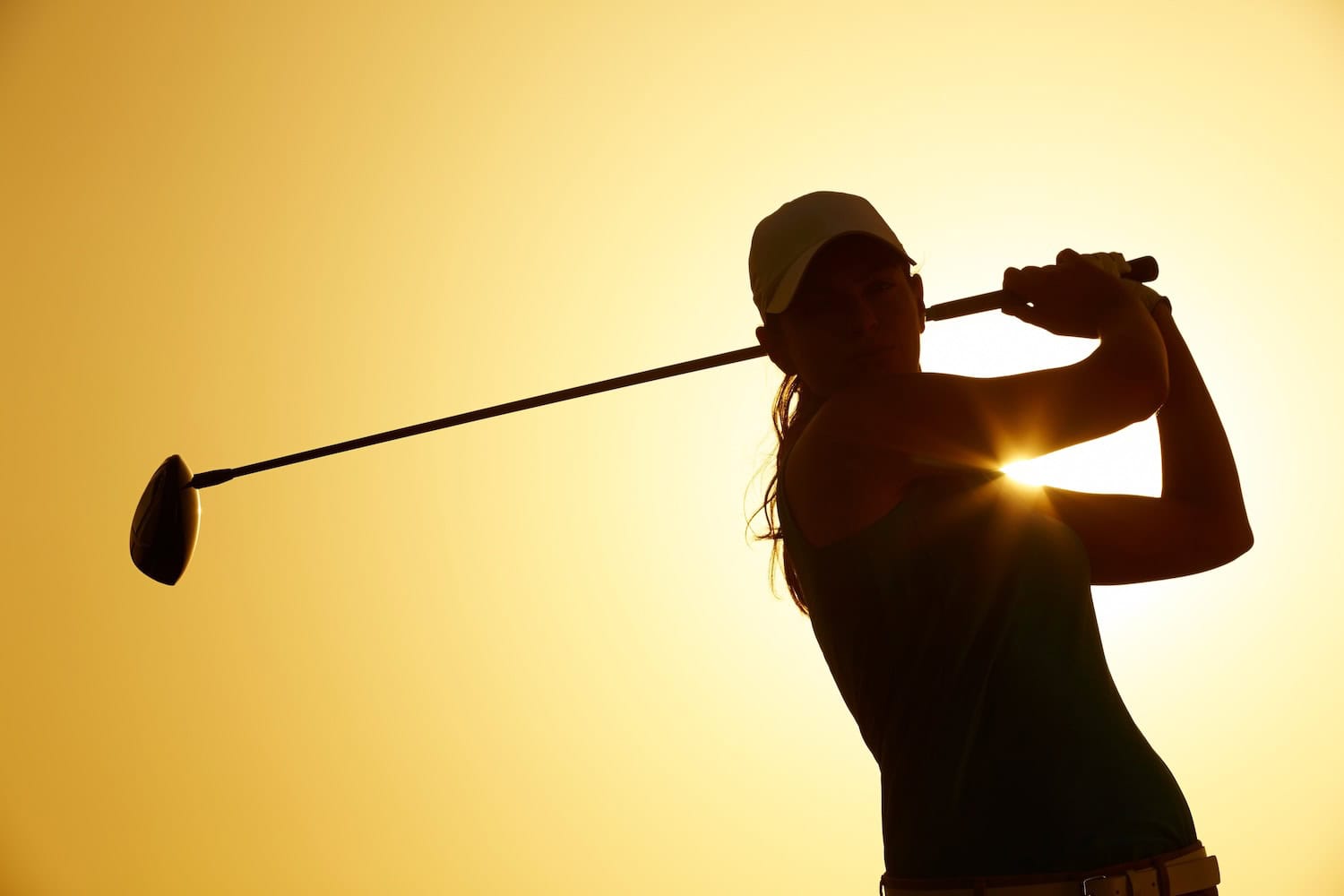 Silhouette einer Frau bei einem Abschlag auf einem Bernhard Langer Golfcourse