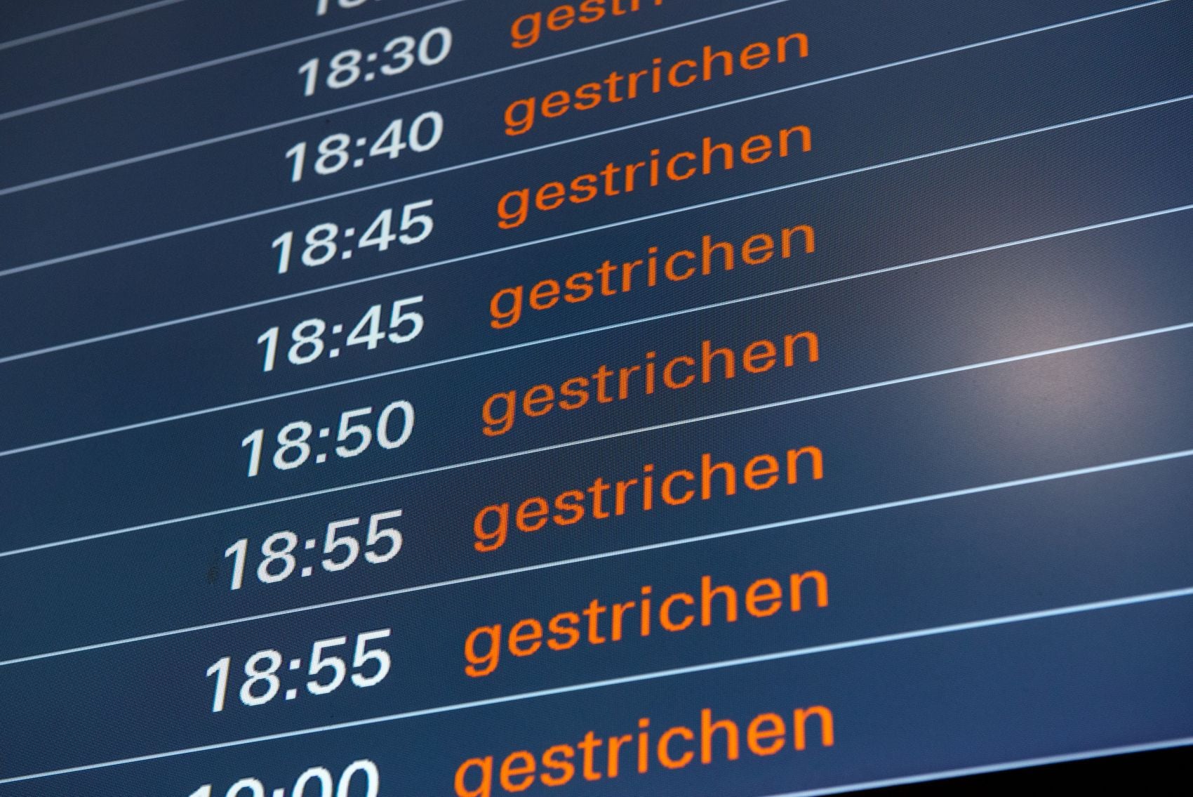 Nahaufnahme eines Bildschirms am Flughafen, auf dem alle Flüge mit "gestrichen" angezeigt werden