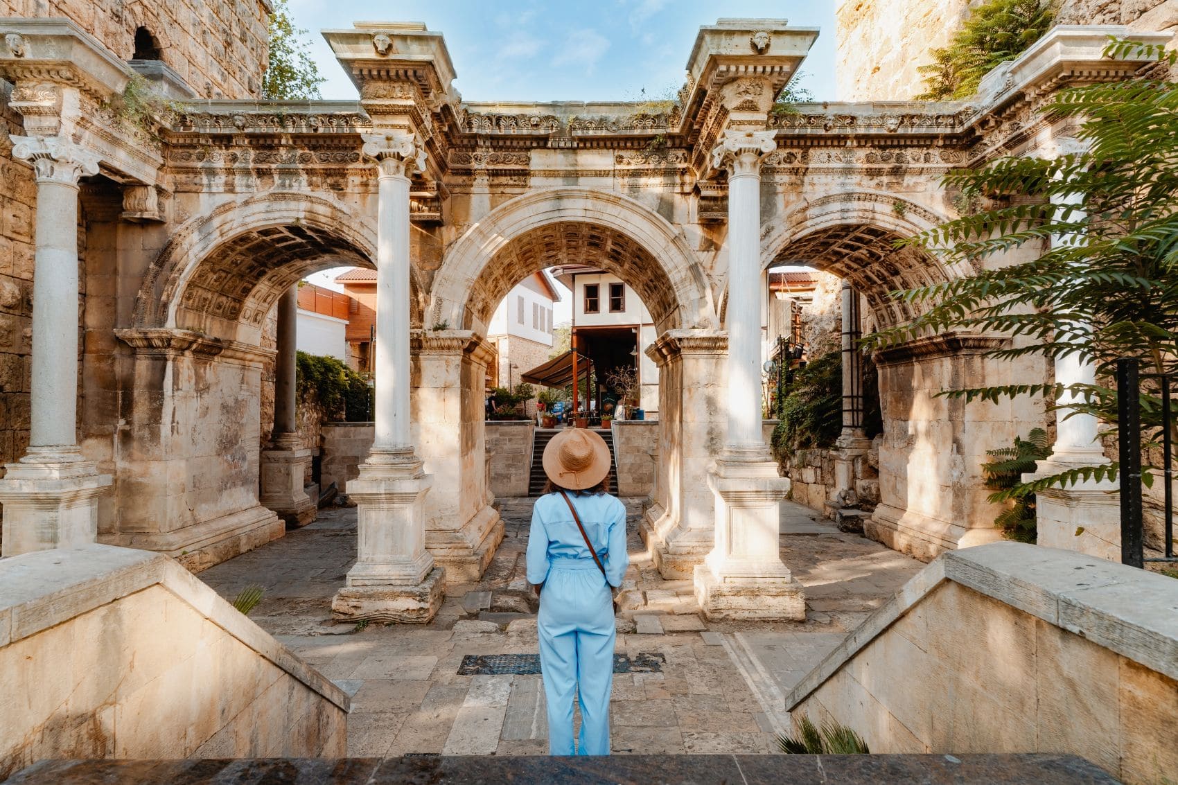 Elegant gekleidete Frau steht vor dem Hadrian-Tor in Antalya