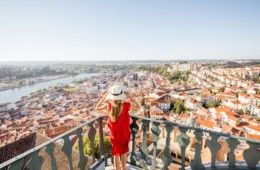 Frau mit Sonnenhut genießt Ausblick auf Coimbra, Portugal