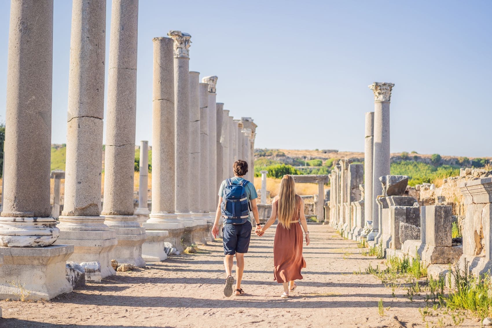 Junges Paar flaniert durch die Ruinen der antiken Stadt Perge bei Antalya, Türkei
