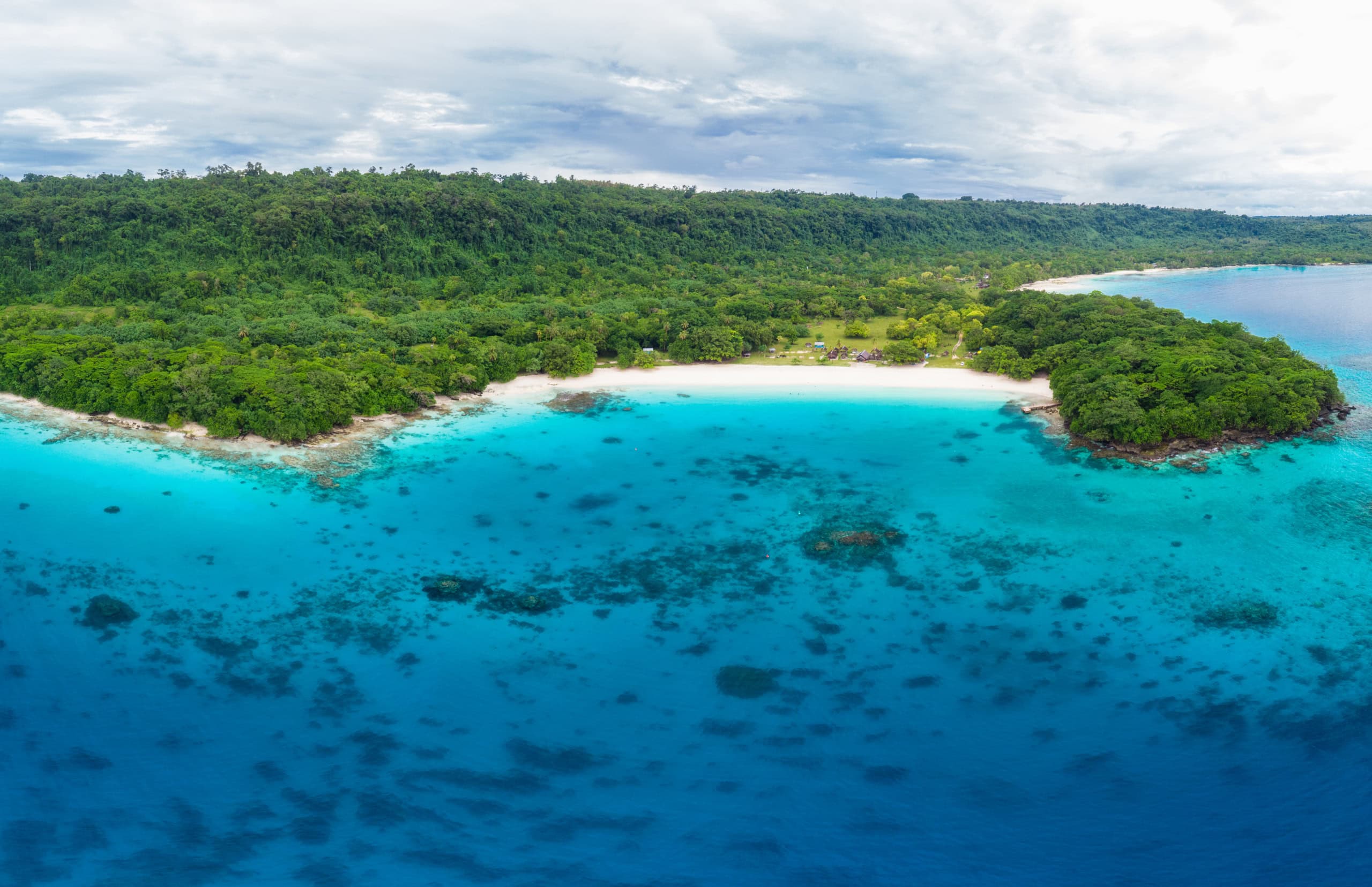 Einsamer weißer Strand mit grünen Urwald und türkisblauem Wasser
