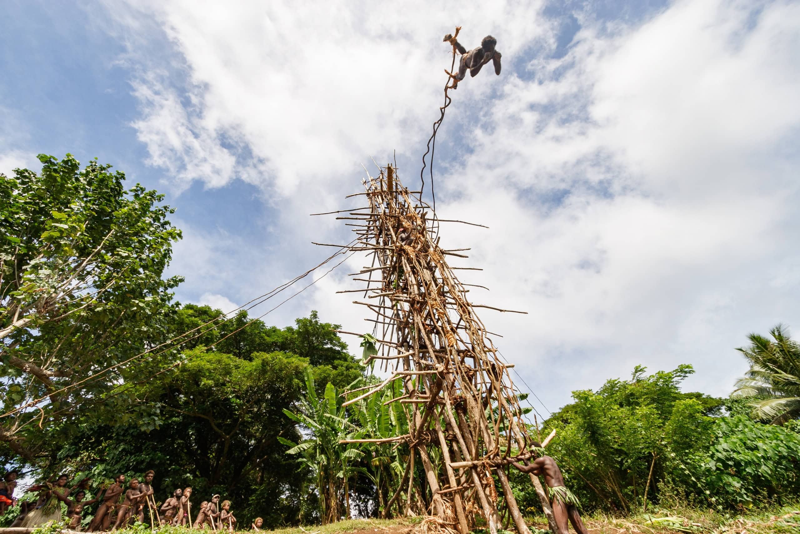 Mann, der von einem hohen, selbstgebauten Turm springt.