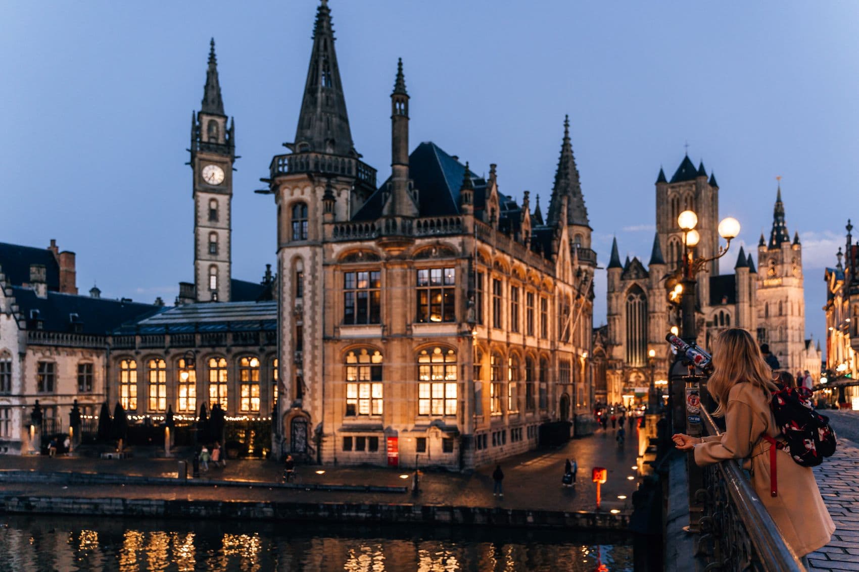 Frau genießt Ausblick von St. Michaels Brücke in Gent am Abend