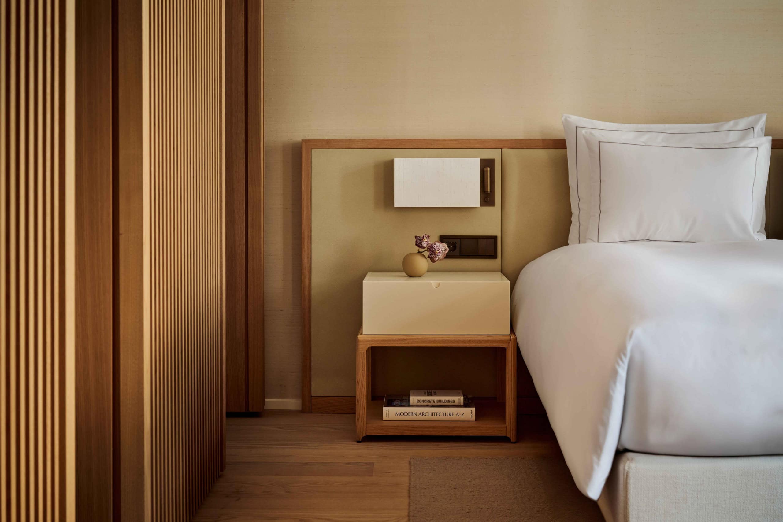 Zimmer im Hotel The Florentin im Frankfurt zeigt ein Bett mit einem Nachttisch.