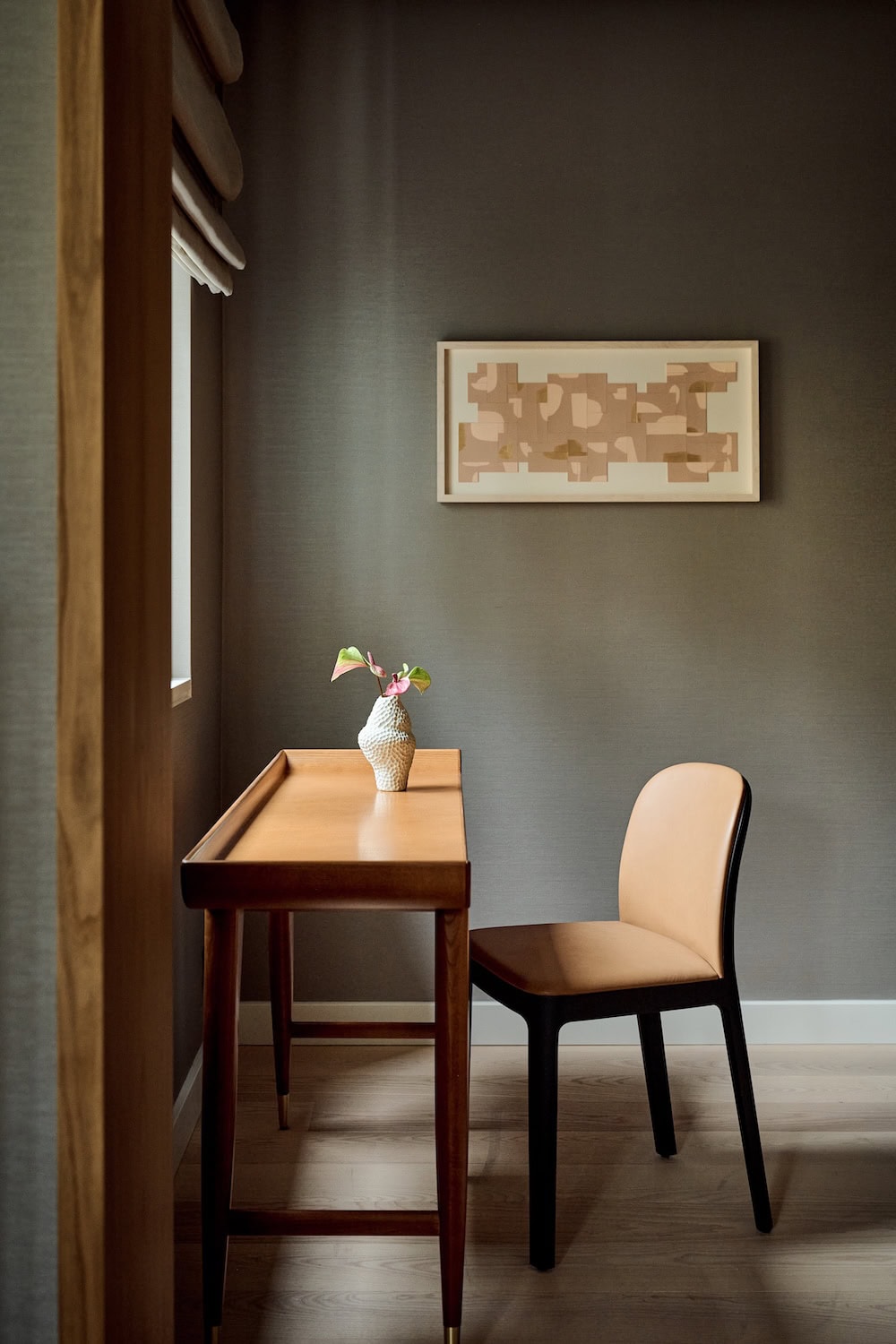 Zurückgenommenes Interieur im The Florentin in Frankfurt. Das Bild zeigt einen schmalen Schreibtisch mit einer Vase und einem Stuhl.