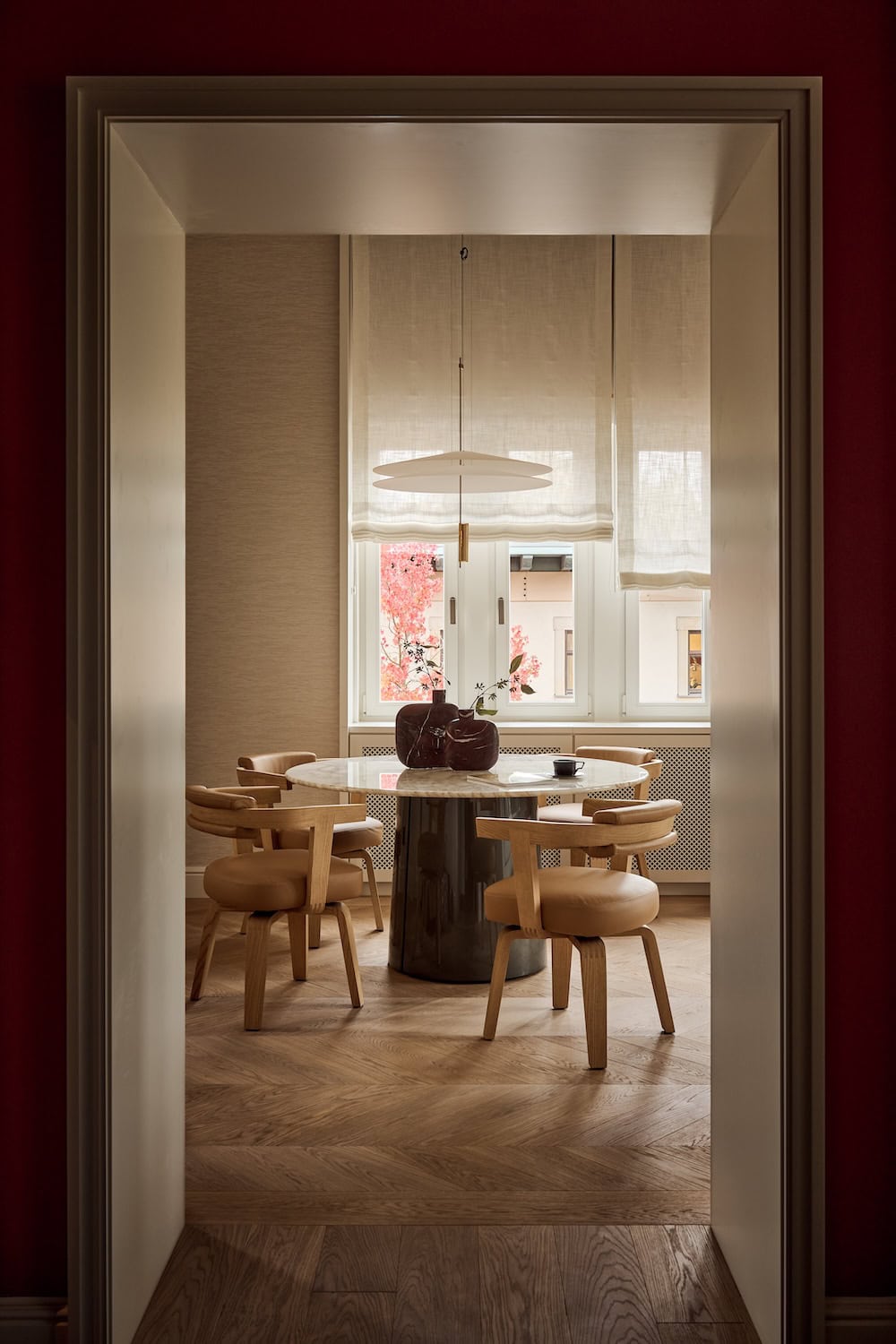 The Tea Room im The Florentin Hotel in Frankfurt. Ein runder Holztisch vor einem Fenster.