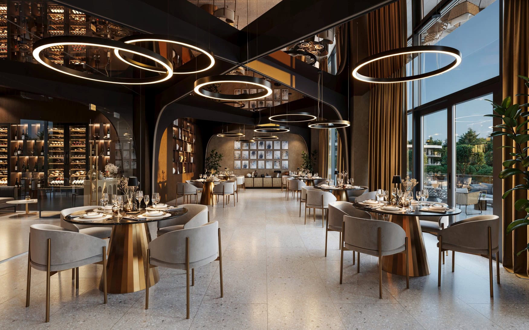 Innenraum eines modernen Restaurants; auf grauen Fliesen stehen mehrere Tischgruppen mit runden Marmortischen und grauen Sitzsesseln. An der Decke hängen moderne, schwarze Rundleuchtet. Rechts geht es zur Terrasse.