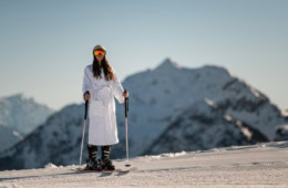 Frau im Bademantel auf Skiern