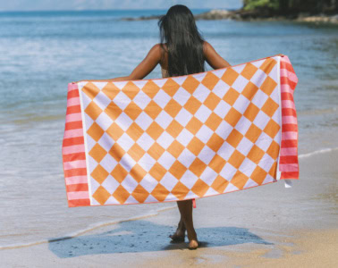 Frau mit Reisehandtuch von Buvanha an einem Strand