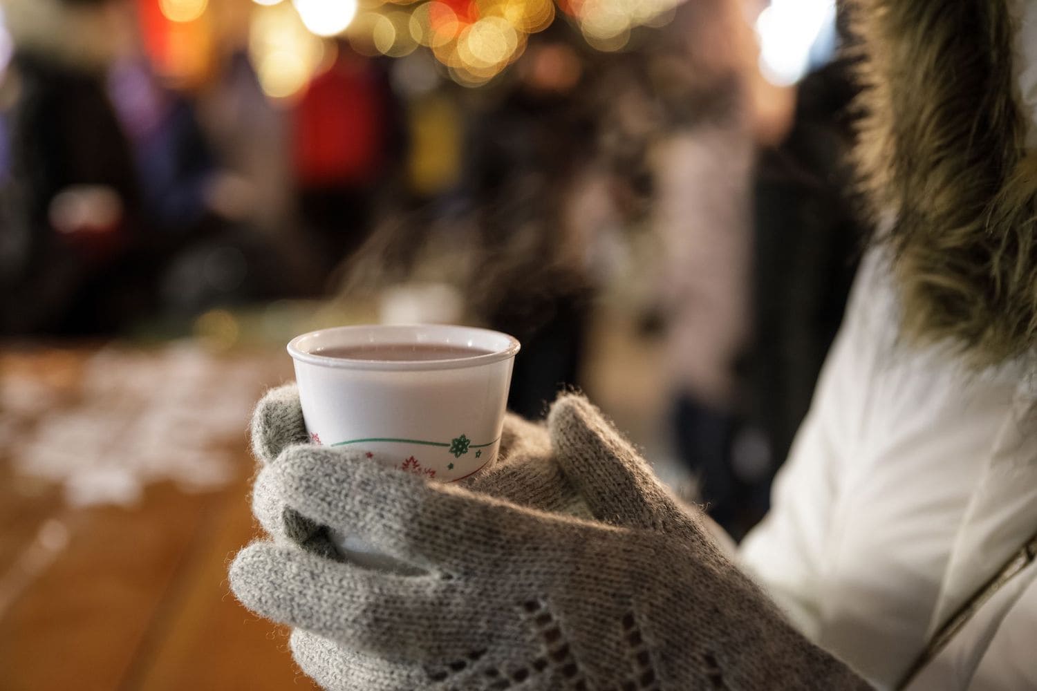 Frau mit Glühwein in der Hand