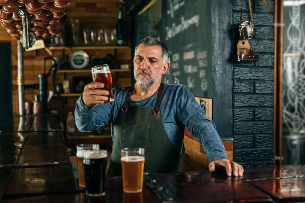Mann schaut verschiedene Biere an