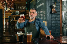 Mann schaut verschiedene Biere an
