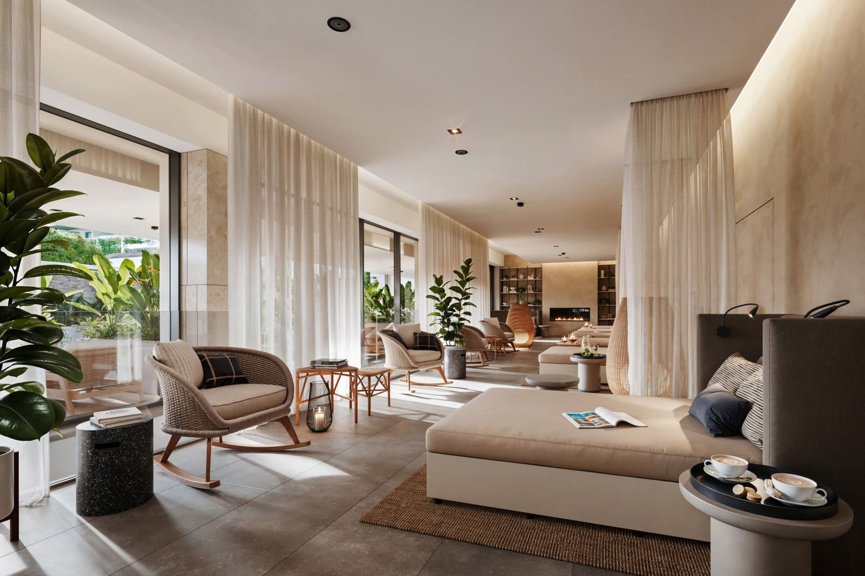 Ruhebreich eines Spas; Ein langezogener, heller Raum mit grauem Fliesenboden. An der rechten Wand stehen mehrere breite Polsterliegen, die durch dünne Vorhänge voneinander getrennt sind, gegenüber jeweils ein grauer Bast-Schaukelstuhl.