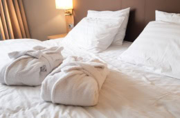 zwei Bademäntel auf dem Bett im Hotel