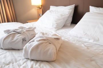 zwei Bademäntel auf dem Bett im Hotel