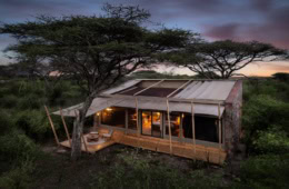 Luxuriöses Zelt mit offenen Dach im Abendlicht der Serengeti.