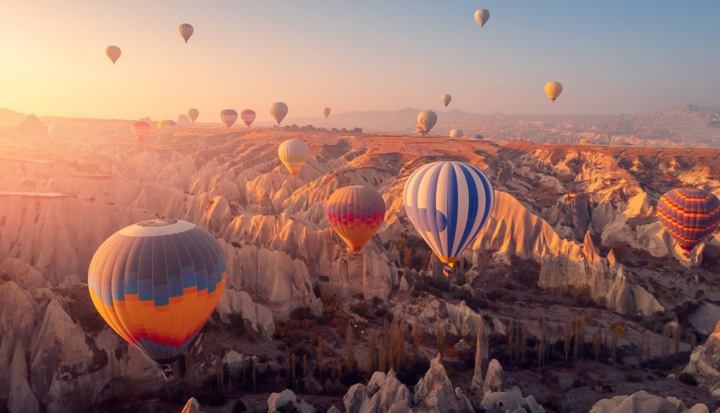 Kappadokien, Ballons im Sonnenaufgang über der Felsenlandschaft.