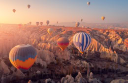 Kappadokien, Ballons im Sonnenaufgang über der Felsenlandschaft.