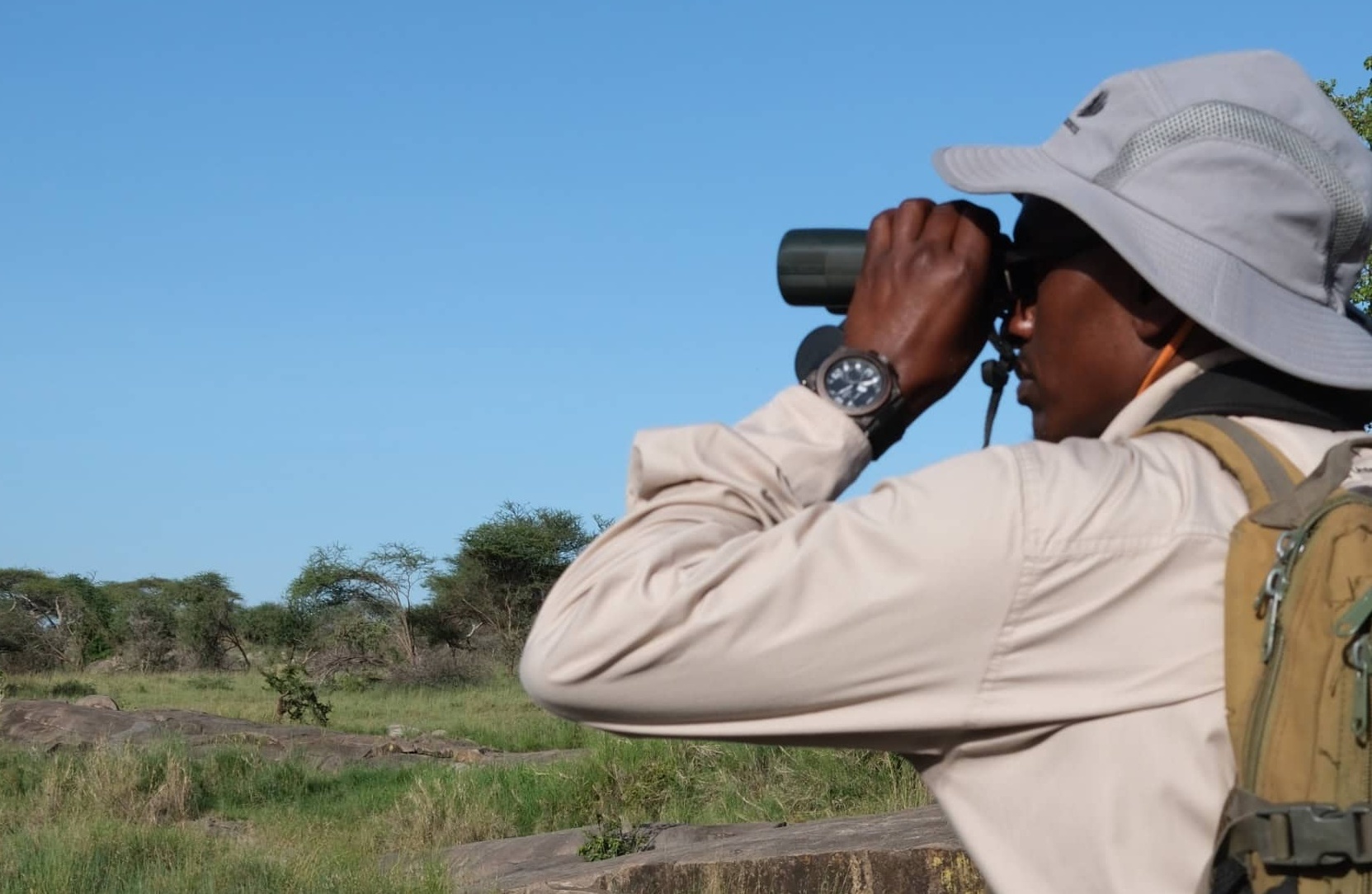 Chrisple Sikawa in der Serengeti – ein Fernglas ist auf Safari in Afrika ein Must-have.