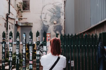 Girl with pierced eardrum von Banksy an einer Hauswand in Bristol