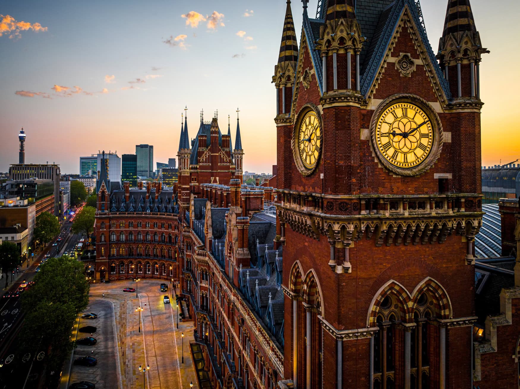 Die beiden Bahnhöfe St Pancras und King's Cross in London, ausgenommen aus einem gegenüberliegenden Gebäude. Im Fokus steht der Uhrenturm des viktorianischen Backsteinbaus.