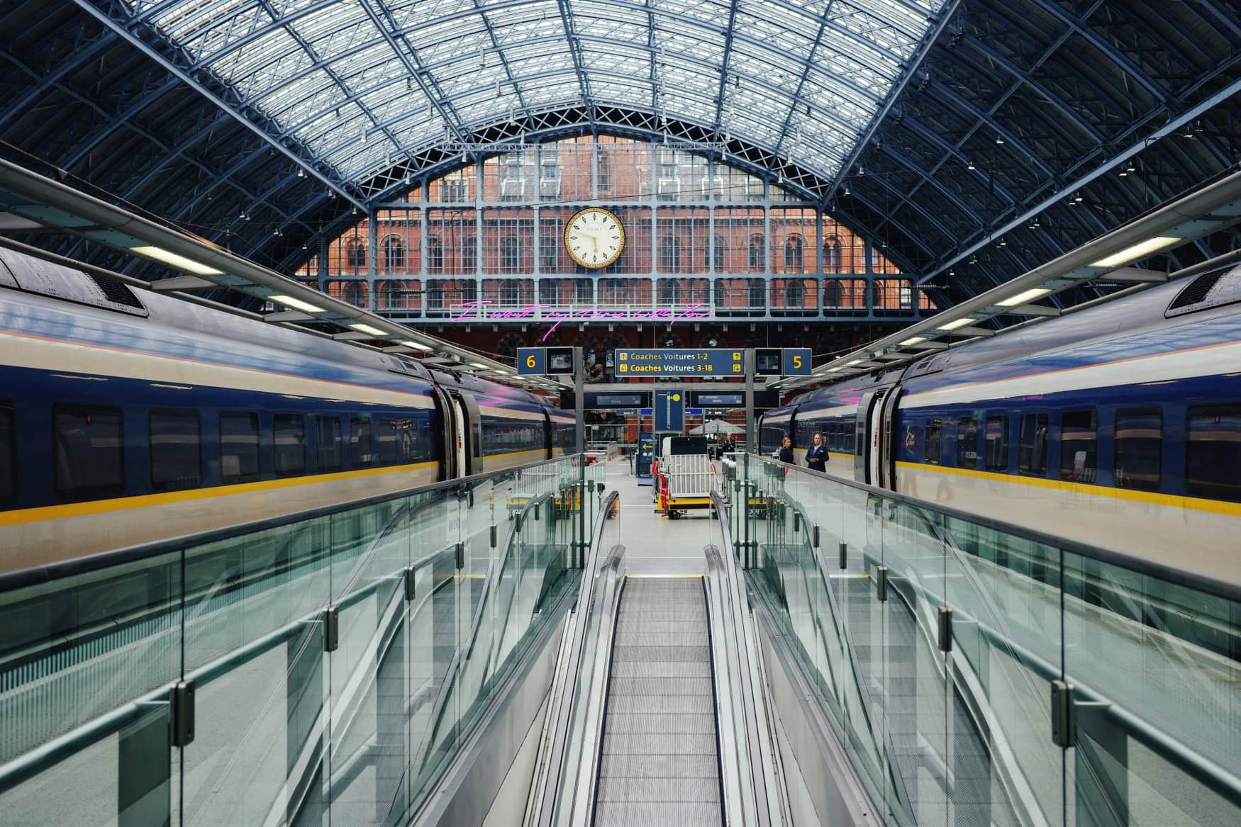 An einem Gleis in London St Pancras stehen zu beiden Seiten weiß-blau-gelbe Eurostar-Züge