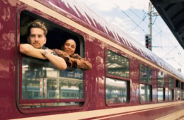Junges Paar blickt aus Nachtzug in Prag im Bahnhof aus dem Fenster