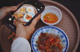 eine Person fotografiert auf Reisen das Essen für Instagram