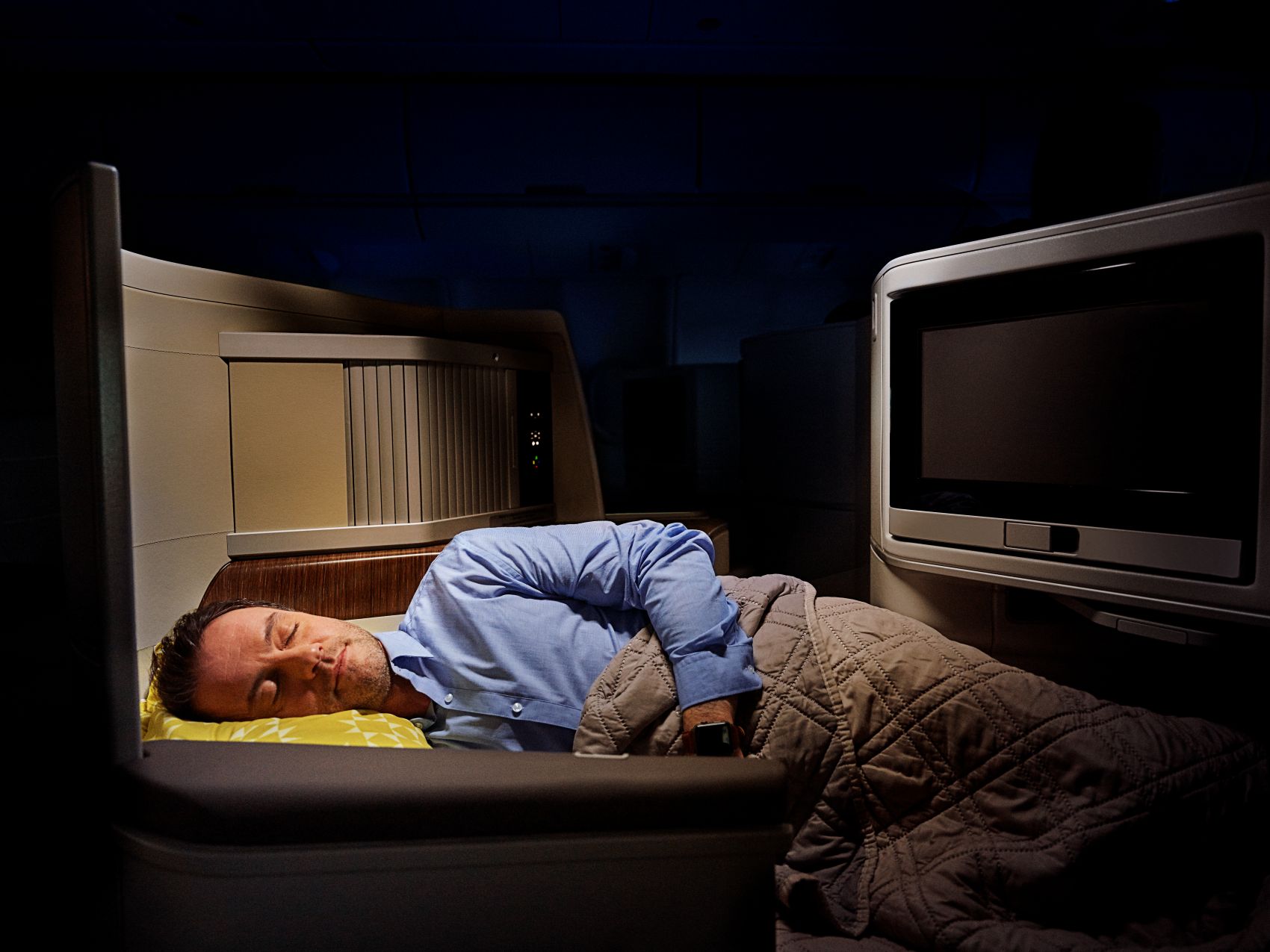 Mann schläft in einem Sitz in der Business Class der TAP Portugal 