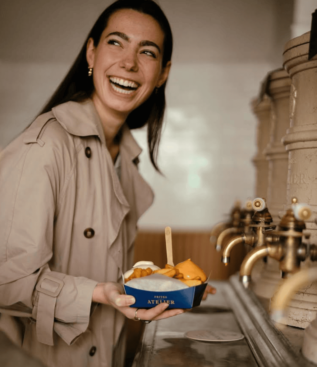 Frau freut sich über ihre Frites im Frites Atelier