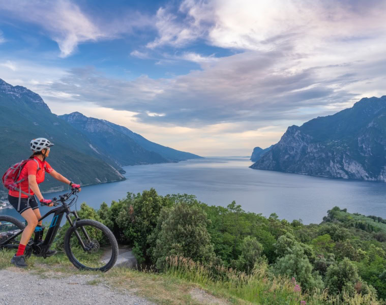Frau mit Mountainbike auf einem Berg mit Blick über den Gardasee