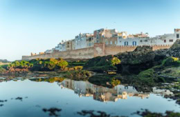 Essaouira vom Meer ausgesehen, im Vordergrund Wasser, hinten die Altstadt, die sich wie eine Burg erhebt.