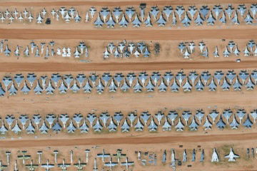 Drohnenansicht des Flugzeugfriedhofs »Boneyard« in Arizona. In der Wüste stehen zahllose ausrangierte Militärflugzeuge nebeneinander.