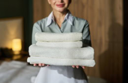 Frau reicht Handtücher im Hotel