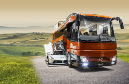 Luxus Wohnmobil mit Garage und Ferrari unterwegs