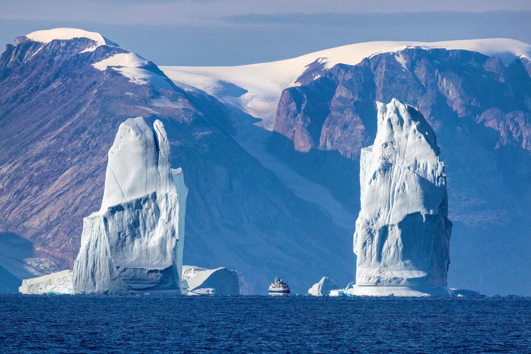 Eisberge und Expeditionsschiff im Scoresby-Sund in Ostgrönland, einem Beobachtungsort der totalen Sonnenfinsternis 2026.