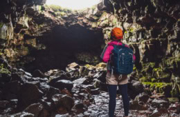 Frau steht am Eingang einer Höhle in Deutchalnd