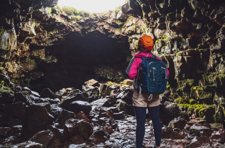Frau steht am Eingang einer Höhle in Deutchalnd